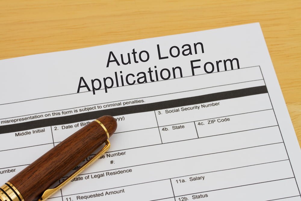 Auto Loan Application Form with a pen on a wooden desk